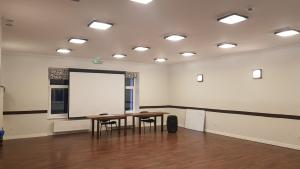a room with a table and two chairs and a white screen at Słoneczna in Miedzygorze
