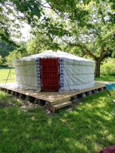 a yurt with a red door on a wooden platform at Yourte mongole véritable in Montcaret