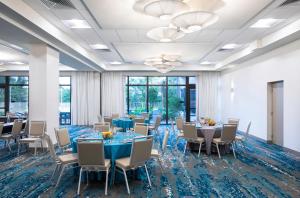 a conference room with tables and chairs and windows at EVEN Hotel Miami - Airport by IHG in Miami