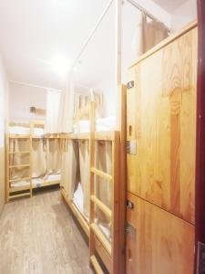a room with several bunk beds and wooden doors at Shanghai Blue Mountain Bund Youth Hostel in Shanghai