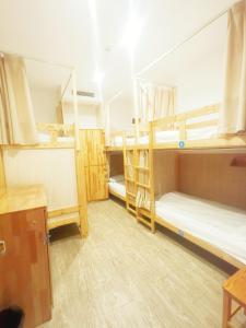a room with three bunk beds and a desk at Shanghai Blue Mountain Bund Youth Hostel in Shanghai