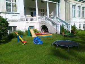 a yard with playground equipment in front of a house at Agroturystyka "Pałac w Janowie" in Janów