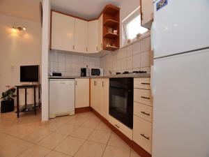 a kitchen with white appliances and a white refrigerator at Apartments Seagull in Postira