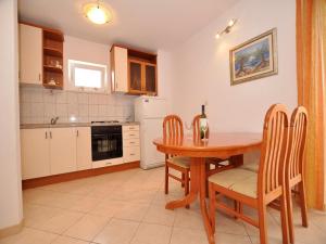 a kitchen with a table with chairs and a bottle of wine at Apartments Seagull in Postira +31 photos
