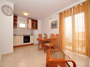 a kitchen and dining room with a table and a clock at Apartments Seagull in Postira