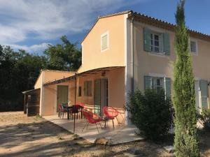 Casa con sillas rojas y patio en La Bastide de l'Olivier, en Flassan