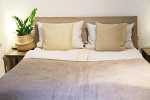 ルストにあるGästehaus Stefan Kochの白いシーツと枕と植物を使用したベッド