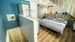 a bedroom with a bed and a staircase with a vase at B&B Joeys place in Egmond aan Zee