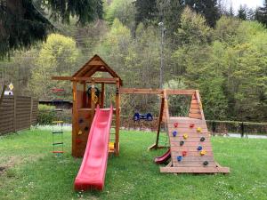 een speeltuin met twee glijbanen en een speelstructuur bij Willa Weronika in Miedzygorze