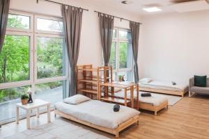 a room with two bunk beds and large windows at Hostel Montessori in Gdańsk