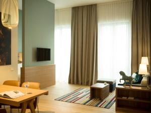 a living room filled with furniture and a tv at The Wellem, in The Unbound Collection by Hyatt in Düsseldorf