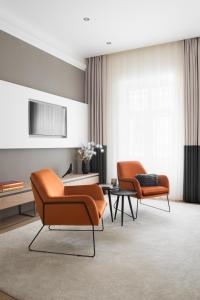 - deux chaises orange et une table dans une chambre dans l'établissement Brill Budapest Apartments 6, à Budapest