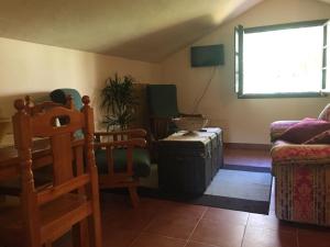 sala de estar con sofá, sillas y ventana en Hotel peñacabrera 1 en Santa Eulalia