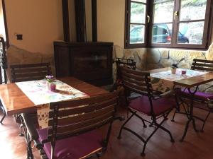 ein Esszimmer mit zwei Tischen und Stühlen sowie einem Kamin in der Unterkunft Hotel peñacabrera 1 in Santa Eulalia