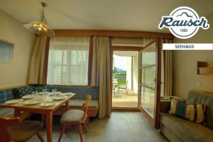 a dining room with a table and a couch at Seehaus Rausch in Egg am Faaker See