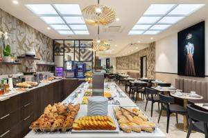 a buffet line with bread and pastries in a restaurant at Best Western Plus Hôtel Massena Nice in Nice