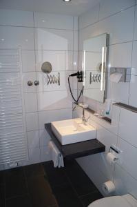 a white bathroom with a sink and a mirror at Hotel St.Martiner Castell in Sankt Martin