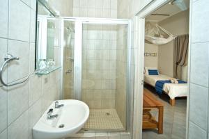 a bathroom with a sink and a shower and a bed at Bahnhof Hotel Aus in Aus