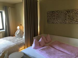 um quarto com uma cama com almofadas cor-de-rosa em Palmina`s Ferienwohnung em Merzig