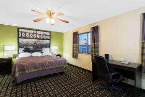 a hotel room with a bed and a desk and window at Super 8 by Wyndham Marietta in Marietta