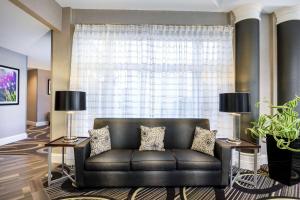 a leather couch in a living room with a large window at La Quinta by Wyndham Myrtle Beach Broadway Area in Myrtle Beach
