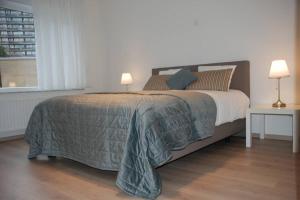 オーステンデにあるAylise vakantiehuisのベッドルーム1室(大型ベッド1台、ランプ2つ付)