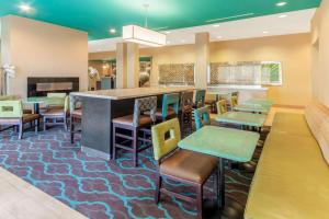 a restaurant with a bar with colorful chairs and tables at La Quinta by Wyndham Carlsbad in Carlsbad