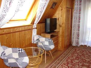 a living room with two chairs and a tv at Kalina 2 in Zakopane