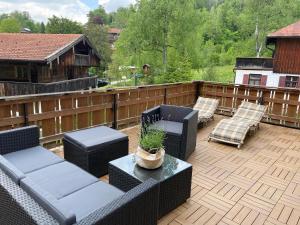 a patio with a couch and chairs on a deck at Apartment am Wildbach - Radeln, Wandern, Natur, Urlaub mit Hund in Fischbachau