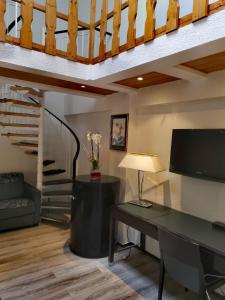 a living room with a desk and a staircase at Bölsche Hotel in Berlin