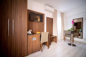 a hotel room with a desk and a television in a room at Anor Hotel & Conference Center Frankfurt Airport in Mörfelden-Walldorf