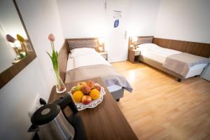 Zimmer mit 2 Betten und einer Obstschale auf dem Tisch in der Unterkunft Anor Hotel & Conference Center Frankfurt Airport in Mörfelden-Walldorf
