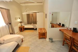 Zimmer mit 2 Betten und einem Bad mit Waschbecken in der Unterkunft Bahnhof Hotel Aus in Aus