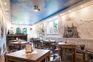 a restaurant with wooden tables and chairs and paintings on the walls at Villa Karpacz, do centrum 900 m, dostępna dieta bezglutenowa z certyfikatem, celiakia in Karpacz
