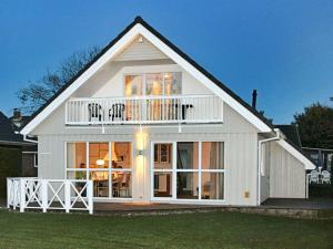 a white house with a balcony on top of it at Three-Bedroom Holiday home in Gelting 7 in Gelting