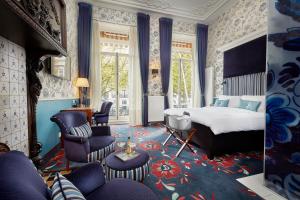 une chambre avec un lit, un canapé et des chaises dans l'établissement Carlton Ambassador, à La Haye