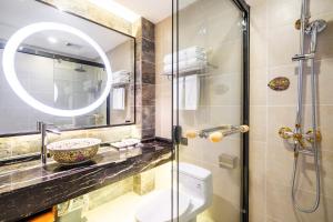 a bathroom with a shower and a toilet and a mirror at Buddha Zen Hotel in Chengdu
