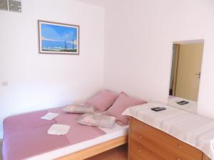 una camera con letto rosa e cassettiera di Villa Šutić a Promajna