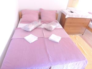 un letto viola con due cuscini sopra in una stanza di Villa Šutić a Promajna