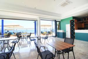 een eetkamer met tafels en stoelen en de oceaan bij Acropol Of Bodrum Beach Hotel in Ortakent