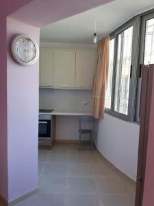 a kitchen with a counter and a clock on the wall at Alexandra Apartament in Sarandë