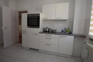 a kitchen with white cabinets and a microwave at Apartment Nürtingen in Nürtingen