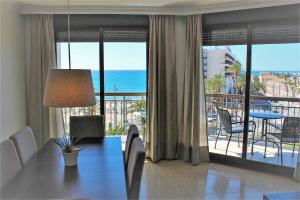 a living room with a table and a view of the ocean at Port-Beach Alicante 1 in Alicante
