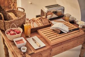 a table with bread and a toaster and a basket of apples at Finca Serena Mallorca, Small Luxury Hotels in Montuiri