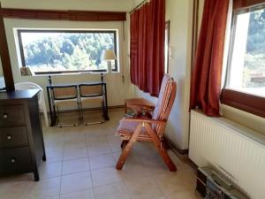 Pokój z krzesłem, stołem i oknem w obiekcie Wildherb House w mieście Agriovótanon