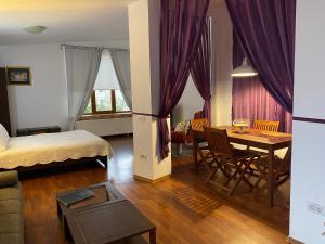 a bedroom with a bed and a table with a dining room at Villa Casafina Serviced Apartments in Mangalia