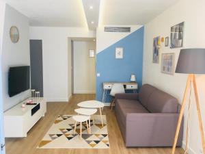 uma sala de estar com um sofá e uma mesa em T2 cosy Port de plaisance Parking-wifi gratuit em Rochefort