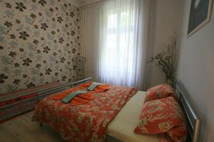 a bedroom with a bed with orange sheets and a window at Apartment No 21 - I P Pavlova 34 in Karlovy Vary