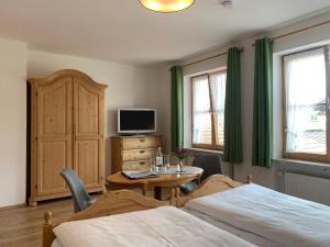 韦尔塔赫Gästehaus "Zur Schmiede"的一间带床、桌子和电视的卧室