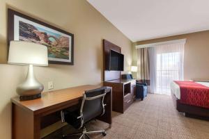 a hotel room with a desk and a bed and a bed and a room with at Comfort Inn & Suites Page at Lake Powell in Page